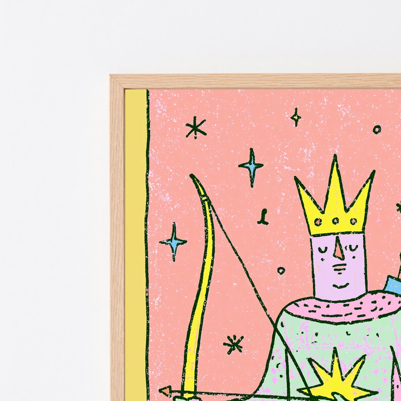 K&ouml;nnte beinhalten: Ein gerahmter Wandkunstdruck mit einer stilisierten Illustration einer Figur mit gelber Krone vor rosa Hintergrund. Die Figur h&auml;lt einen gelben Bogen und Pfeil, umgeben von blauen Sternformen. Der Druck befindet sich in einem hellen Holzrahmen.