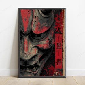 K&ouml;nnte beinhalten: Ein rechteckiger Wandkunstdruck mit einer Nahaufnahme eines grauen Hannya-Masken-Motivs mit markanten H&ouml;rnern. Das Kunstwerk ist mit leuchtend roten Farbspritzern akzentuiert und enth&auml;lt ein vertikales rotes Feld mit schwarzem japanischem Kanji-Text.