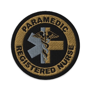 May include: A round, black embroidered patch with gold lettering that reads "Paramedic Registered Nurse". The center of the patch features a gray and gold medical symbol with a snake and wings.