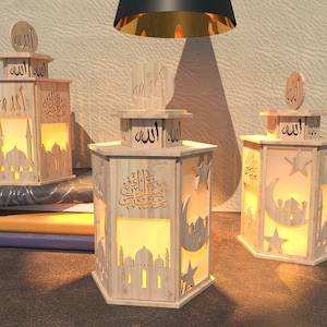 Könnte beinhalten: Drei Holzlaternen mit filigranen Ausschnitten von islamischer Kalligraphie, Sternen und Mondsicheln. Die Laternen sind von innen beleuchtet und strahlen ein warmes Licht aus. Die Laternen sind eine traditionelle islamische Dekoration.