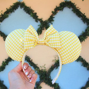 May include: Yellow and white gingham Minnie Mouse ears headband with a large bow.