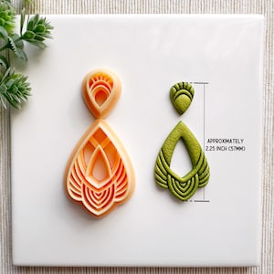 May include: Two polymer clay earring molds, one orange and one green, in the shape of a teardrop with intricate geometric designs. The molds are approximately 2.25 inches (57 mm) tall.