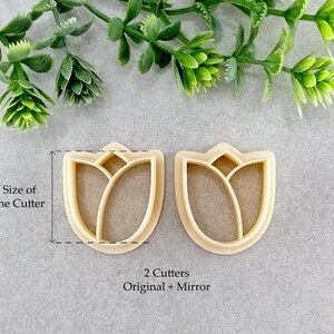 May include: Two plastic cookie cutters in the shape of a tulip. The cutters are beige and have a detailed design. The text "2 Cutters Original + Mirror" is printed below the cutters.