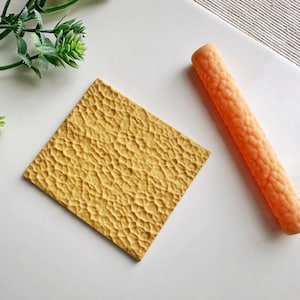 May include: A set of two yellow textured silicone rolling pins for baking and crafting. The larger rolling pin is flat and the smaller rolling pin is round.