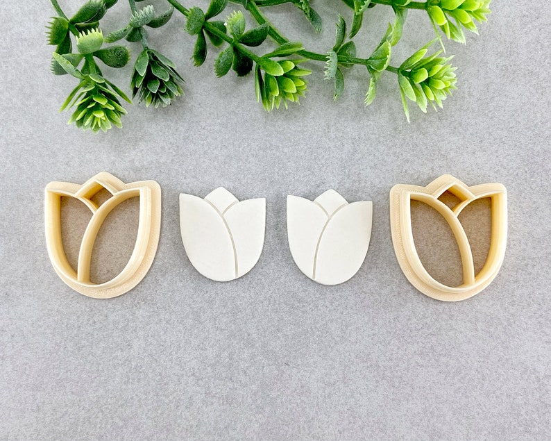 May include: Three cookie cutters shaped like a tulip flower. The cutters are made from a light brown plastic material.