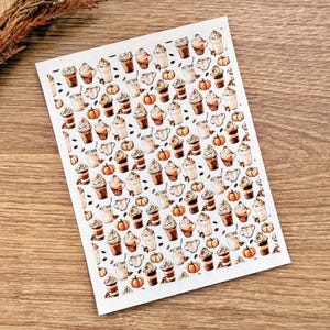 Op de afbeelding: Een vel stickers met een herhalend patroon van herfstthema-illustraties. De ontwerpen omvatten koffiedranken met slagroom, pompoenen en koffiekopjes. De stickers zijn in tinten bruin, oranje en wit.