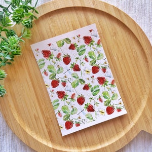 Puede incluir: Una tarjeta blanca con un patrón repetido de fresas rojas, hojas verdes y pequeñas flores blancas. Las fresas están dibujadas en estilo acuarela.
