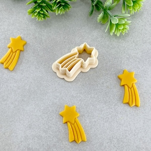 Può includere: Quattro stampini per biscotti a forma di stelle cadenti. Tre sono gialli e uno è bianco.