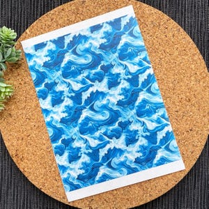 Puede incluir: Una impresión abstracta azul y blanca con un patrón de remolino que recuerda a las olas.
