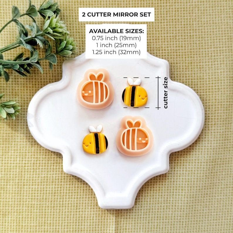 Pode incluir: Quatro cortadores de biscoitos em forma de abelha, dois de cada desenho, em um conjunto espelhado. Os cortadores s&atilde;o de cor p&ecirc;ssego claro, com abelhas listradas em amarelo e preto. Tamanhos dispon&iacute;veis: 19 mm, 25 mm e 32 mm. O texto diz: '2 CUTTER MIRROR SET'.