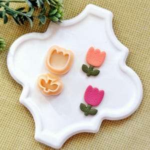 May include: A handmade, wooden serving tray with a natural finish. The tray features a rectangular shape with rounded corners and two carved handles. The wood grain is visible, adding to its rustic charm. Dimensions are approximately 16 inches long and 10 inches wide.