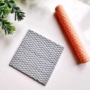 May include: A gray silicone rolling pin with a fish scale pattern and a matching silicone mat with the same pattern.