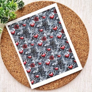 May include: A black and white patterned paper with red hearts and roses. The pattern is repeated throughout the paper.