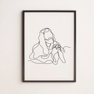 Könnte beinhalten: Gerahmter Kunstdruck mit einer minimalistischen Strichzeichnung einer Person mit langen Haaren, die Hände zum Gebet gefaltet. Das Kunstwerk ist eine einzige durchgehende schwarze Linie auf weißem Hintergrund, in einem schwarzen Rahmen.