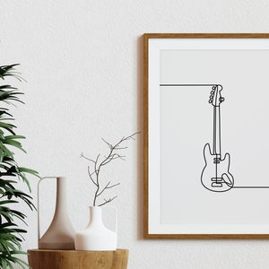 May include: A framed print of a line drawing of a bass guitar in black on a white background. The frame is brown wood.