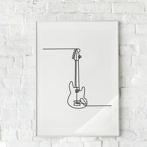 May include: A black and white line drawing of a bass guitar hanging on a white brick wall in a framed print.