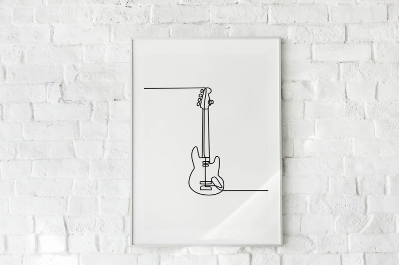 May include: A black and white line drawing of a bass guitar hanging on a white brick wall in a framed print.