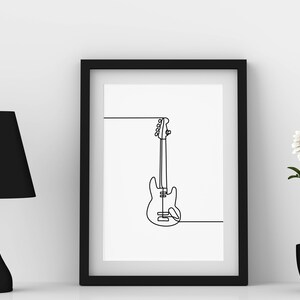 May include: A black framed print of a line drawing of a bass guitar hanging on a white wall. A black lamp and a potted white flower are on a white surface.