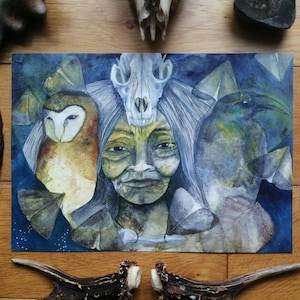 May include: Watercolor painting featuring a central female figure with an owl and a bird-like figure on either side. A skull rests atop the woman's head. The artwork is set against a dark blue background, with feathers and antlers surrounding the painting.