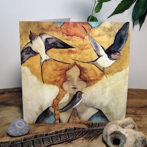 May include: Watercolor art print featuring a woman with flowing red hair and three swallows in flight. The artwork has a warm color palette with shades of gold, orange, and blue. The woman has her eyes closed, and a swallow rests on her shoulder.