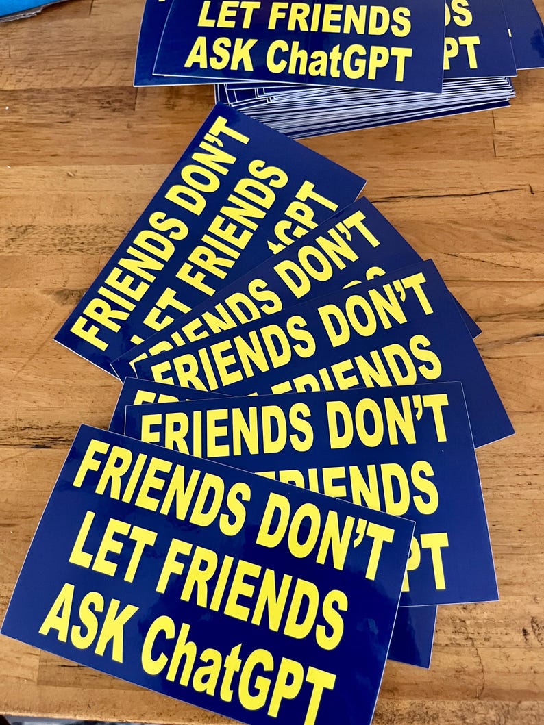 May include: A stack of blue rectangular stickers with yellow text. The text on the stickers reads "FRIENDS DON'T LET FRIENDS ASK ChatGPT". The stickers are arranged on a wooden surface.