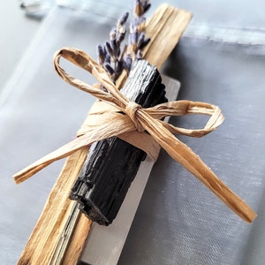 Peut inclure: Un paquet de bâtonnets de purification liés avec un nœud en ficelle naturelle. Le paquet comprend du palo santo, de la sauge blanche et de la tourmaline noire. Des fleurs de lavande séchées sont incluses dans le paquet.