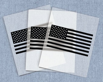 May include: Three sheets of clear vinyl with a black and white American flag design printed on each sheet. The flags are layered on top of each other, creating a layered effect.