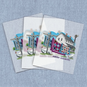 May include: Illustration of an Amish country scene with a farmhouse, quilts, chickens, and the text "Amish Country". The quilts are displayed on a clothesline. The image is on a light blue background.