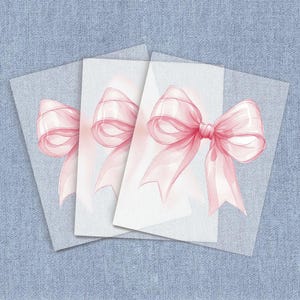 May include: Four white cards with pink ribbon bows on each. The bows are translucent and have a watercolor effect.