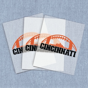 May include: Three sheets of clear vinyl with a black and orange design of a football with the text "Cincinnati" printed on it.