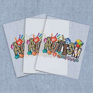 May include: Three white sheets of paper with the word "AUTISM" in colorful letters with puzzle pieces, handprints, and a ribbon. The word "acceptance" is written below the word "AUTISM".