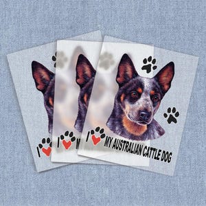 May include: Three white stickers with a blue heeler dog on each. The stickers have paw prints and hearts. The text on the stickers reads "I love my Australian Cattle Dog."