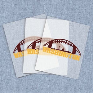 May include: Three white sheets with a football design in burgundy and gold. The design includes the word "WASHINGTON" and a silhouette of the city's skyline. The sheets are layered on a light blue textured background.