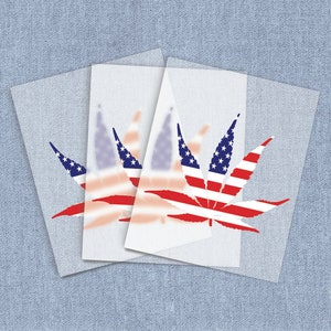May include: Three white sheets of paper with a red, white, and blue marijuana leaf printed on them. The leaf is stylized to look like the American flag.