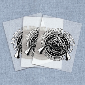 May include: Black and white sticker with a graphic of two crossed rifles in front of a circle with the words "American Liberty" and "The Second Amendment" around the outside. The circle also has the words "Live Free" and "1776" inside.