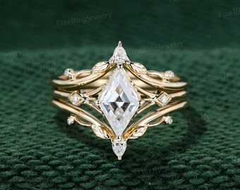 May include: A gold ring set with a large, clear, square-shaped diamond. The ring has a delicate, vine-like design with small diamonds on the band.
