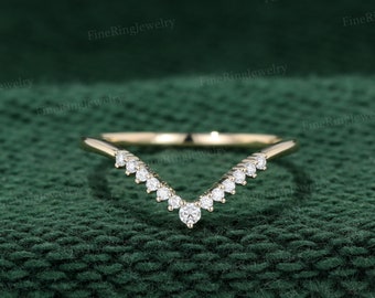 May include: A delicate gold band with a V-shaped row of small diamonds.