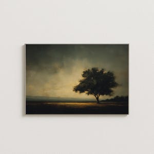 May include: A framed landscape painting depicts a solitary tree in a field under a dramatic, cloudy sky. The artwork features a dark color palette with shades of brown, green, and gold, creating a moody and atmospheric scene.