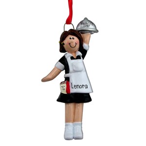 May include: A personalized Christmas ornament featuring a cartoon waitress wearing a black and white uniform, holding a silver tray with the words "Windy City Diner" on it. The ornament has the name "Lenora" written on it.