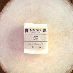 May include: A bar of handmade soap with a brown label that reads "Kettle Works Handcrafted Soaps Ocean Waves Made in Chester, NJ Net Wt 4 oz".