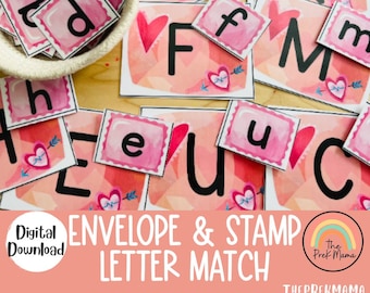 Op de afbeelding: Een educatief spel met Valentijnsdagthema voor kinderen. Het spel bevat roze enveloppen met letters erop en roze postzegels met letters erop. Het spel heet "Envelope & Stamp Letter Match".