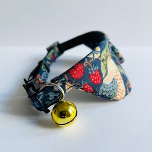 May include: A blue and white patterned cat collar with a gold bell. The collar has a breakaway buckle and is designed for small pets.