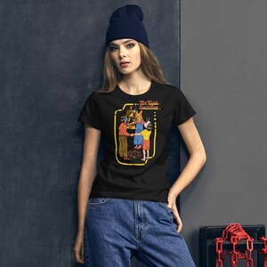 May include: A black t-shirt with a graphic of a group of people performing a ritual with the text "My First Sacrifice..." printed on the front.