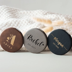 three personalized coasters sitting on top of a white blanket