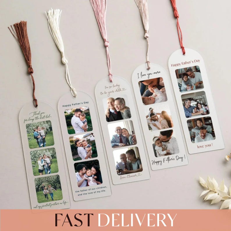 a collection of five white tassel bookmarks, each with a photo of a family, arranged on a light-colored surface. The bookmarks are designed to be used as reading aids, with each page featuring a different family photo. The bookmarks are accompanied by a small branch of white flowers, adding a touch of natural beauty to the scene.