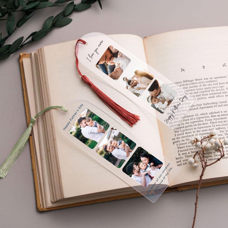 a pair of clear photo-editing bookmarks with printed family photos, placed on top of an open book.