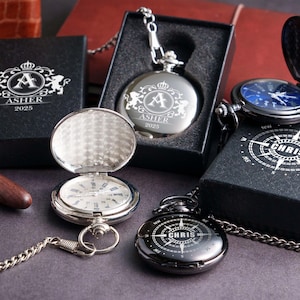 A collection of pocket watches and boxes with personalized engravings, including the name "Ashler" and the year "2025".