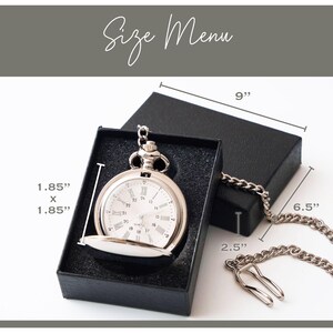 A silver pocket watch is displayed in a black box, with measurements provided.