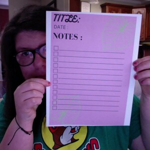 May include: A pink checklist with the words "TITLE:" and "NOTES:" at the top. There are 15 blank lines with checkboxes next to each line.