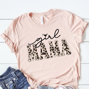 May include: A pink t-shirt with the text "girl mama" in black lettering with a leopard print pattern.